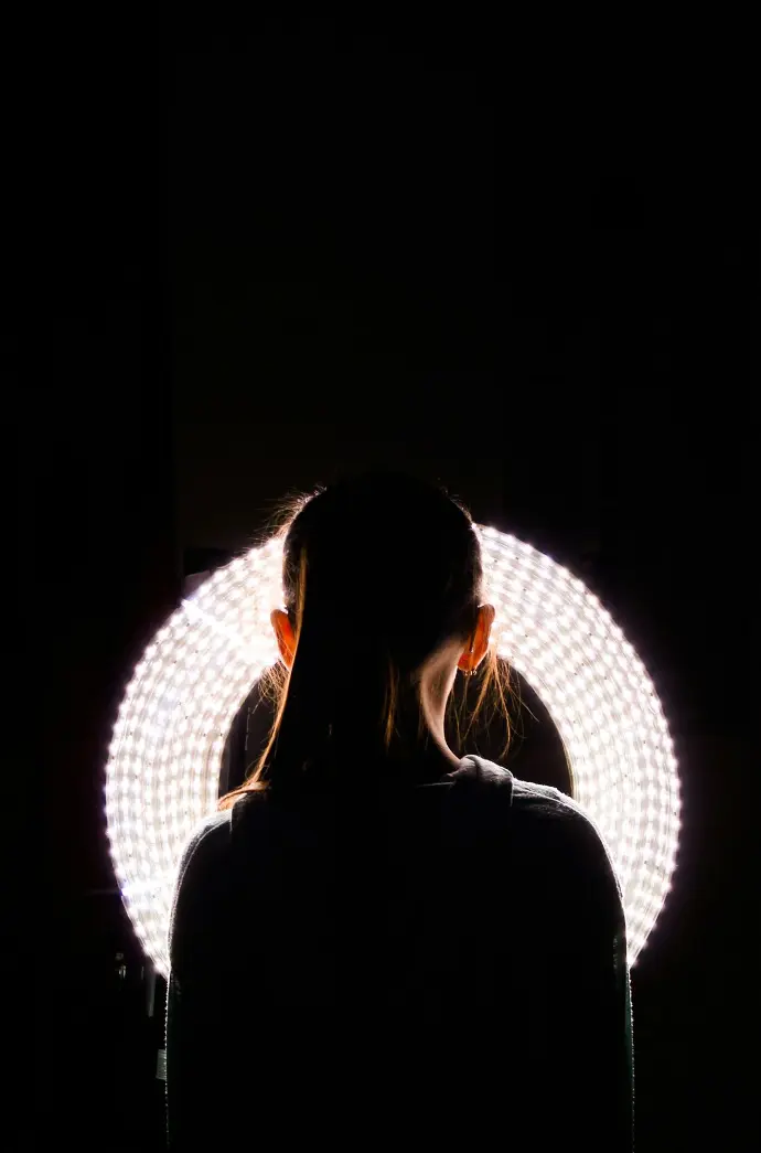 woman standing near round white vanity light